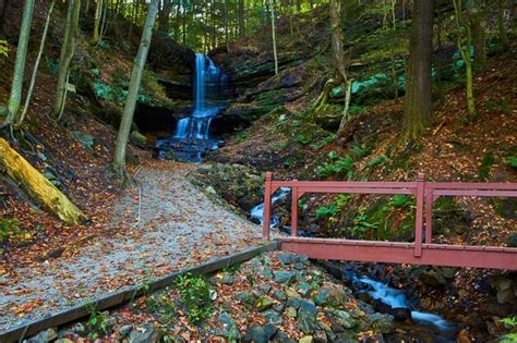 Premium Photo Autumn Waterfall And Bridge In Serene Woodland Scene