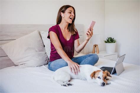 Happy Young Caucasian Woman At Home Working On Laptop And Mobile Phone