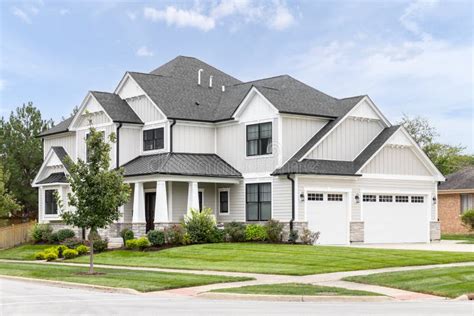 A Tan And White Modern Farmhouse With A Covered Front Porch Stock