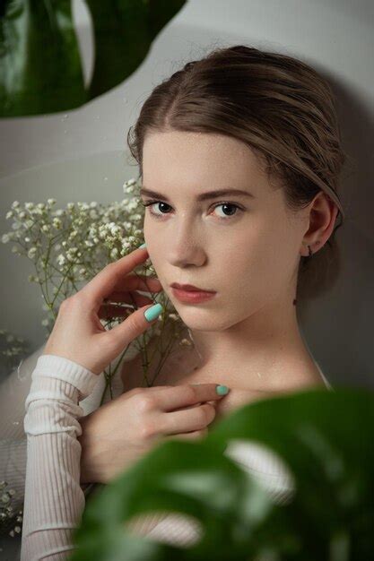 Premium Photo Blonde Woman In Bath With Flowers And Green Leaves