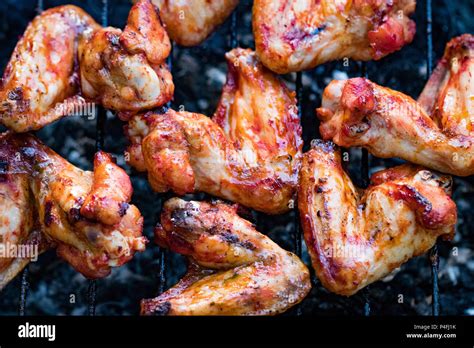 Spicy Marinated Chicken Wings Grilling On A Summer Barbecue With Hot Flames In A Close Up View