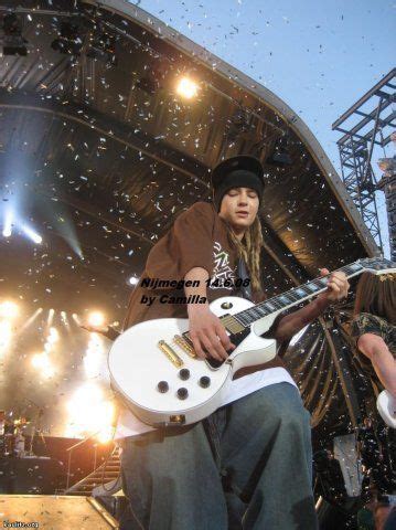 A Man Playing An Electric Guitar In Front Of A Crowd At A Music