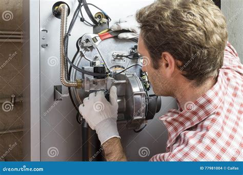 Plumber Repairing A Condensing Boiler In The Boiler Room Stock Photo