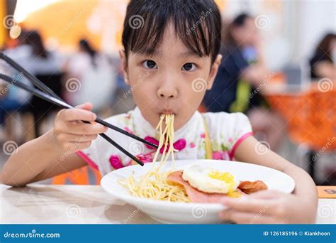 Asian Chinese Little Girl Eating Noodles with Chopsticks Stock Photo - Image of malaysian ...