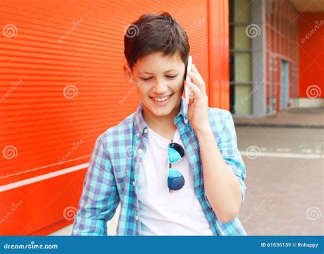 Menino De Sorriso Do Adolescente Do Retrato Que Fala No Telefone Imagem