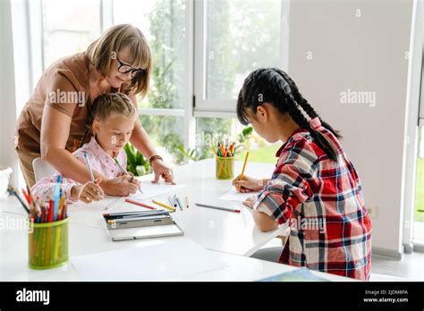 Mature Teacher Drawing With Her Pupils During Class In Art School Indoors Stock Photo Alamy