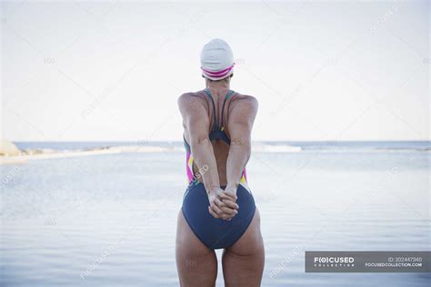 Female Swimmer Stretching At Ocean Outdoors — Daytime Background