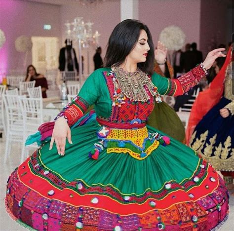 A Woman In A Green And Red Dress Dancing On The Dancefloor At An Event