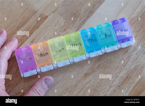 A Man Organising Weekly Medication Tablets Or Pills In A Pill Organiser