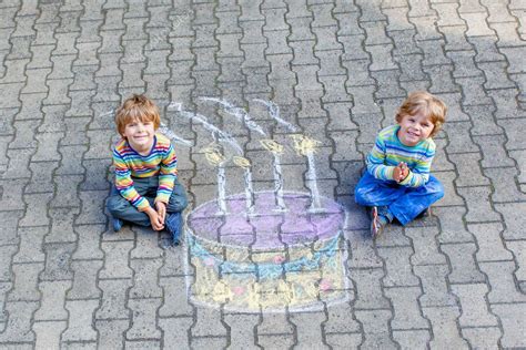 Dos niños se divierten con el dibujo colorido de la torta de cumpleaños