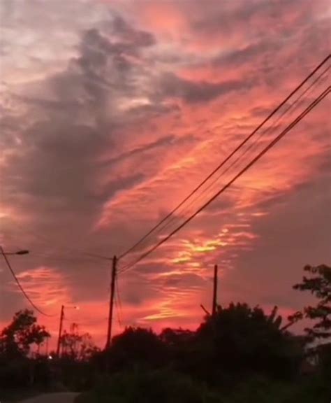 The Sun Is Setting Behind Power Lines And Telephone Poles In An Area