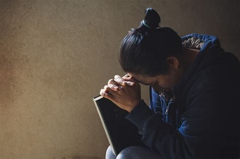 Premium Photo Hands Folded In Prayer On A Holy Bible In Church