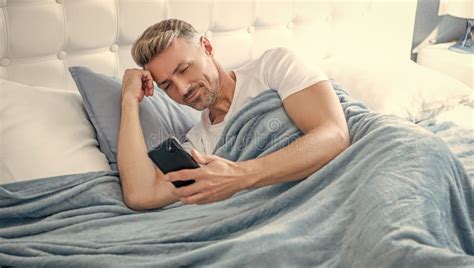 Cheerful Mature Man In Bed Chatting On Phone Stock Image Image Of