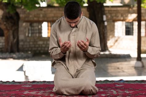 Jovem Mu Ulmano Fazendo Ora O Tradicional A Deus Enquanto Usava Um