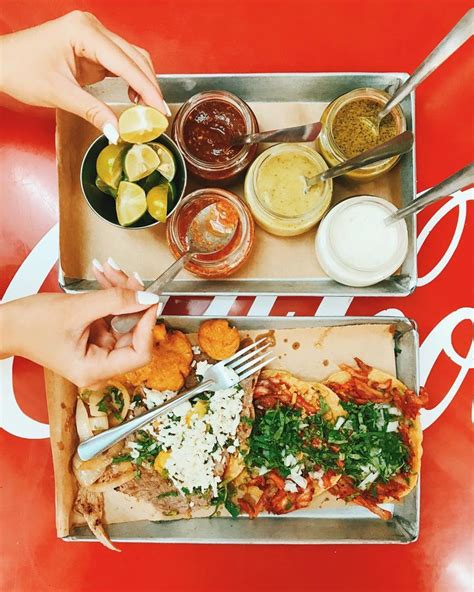 Two Trays Filled With Different Types Of Food On Top Of A Red Tablecloth