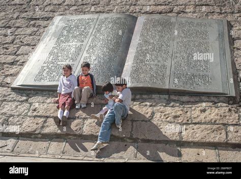 Los Ni Os Se Sientan Junto A La Escultura De Libros En La Base Del