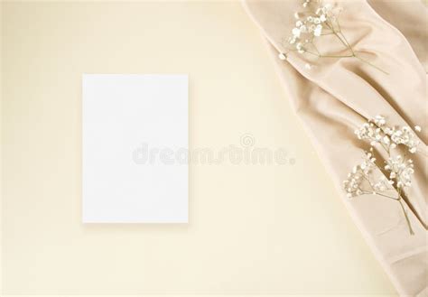 Mockup Wedding Invitation Card With White Gypsophila And Nude Fabric On The Beige Background