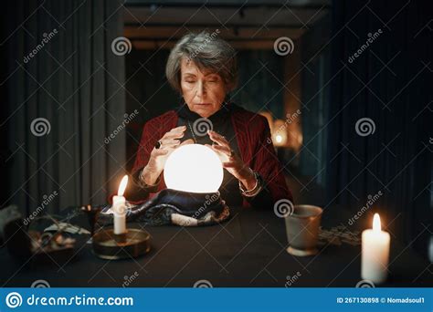Portrait Of Old Mature Fortune Teller Looking Into Crystal Ball Stock