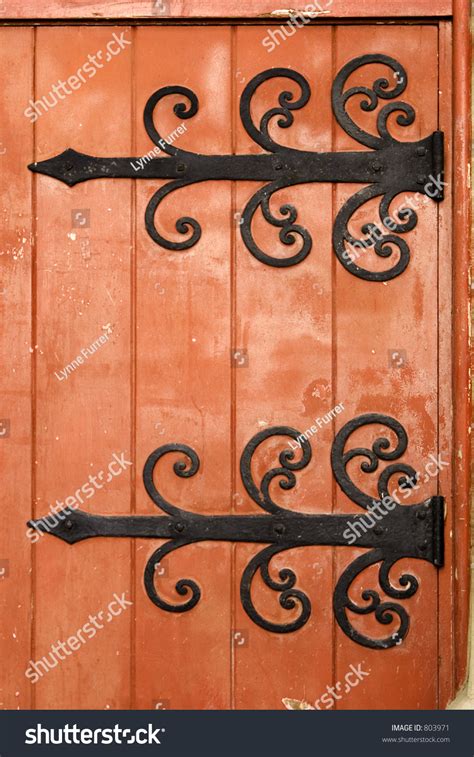 Fancy Ornate Black Iron Hinges Hold An Old Wooden Door Painted A