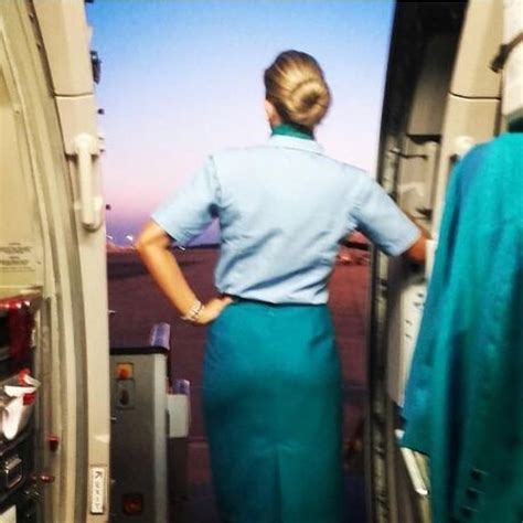 A Woman Standing In The Doorway Of An Airplane