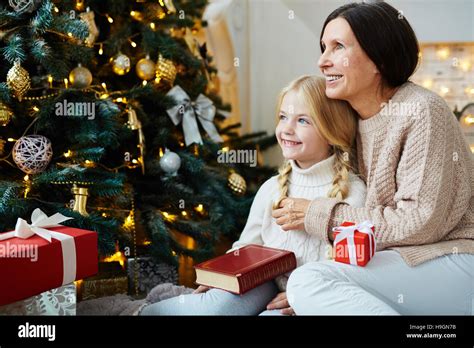 Mature Woman With Granddaughter Sitting By Decorated Firtree Stock Photo Alamy