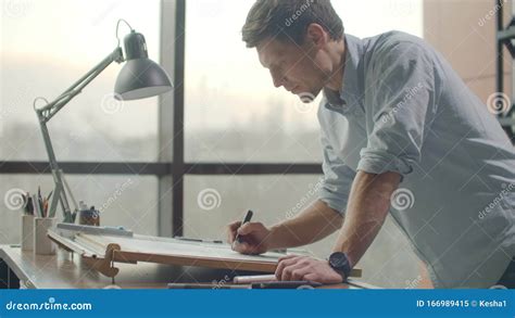 Un Hombre Es Un Joven Arquitecto Moderno Sentado En Una Mesa Dibujando