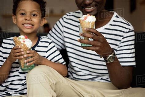 Cropped Shot Of Smiling African American Father And Son Eating Ice