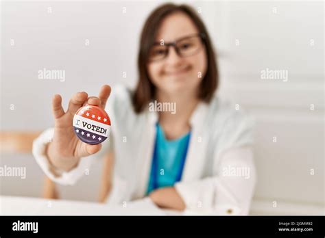 Brunette Woman With Down Syndrome Smiling Holding Vote Badge At