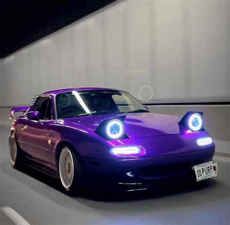 A Purple Sports Car Driving Down The Road