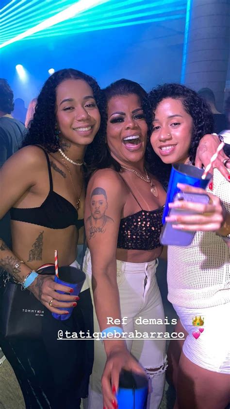 Three Women Standing Next To Each Other In Front Of A Blue Light At A Party