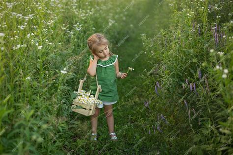 Premium Photo The Girl Walks Among The Tall Grass And Flowers