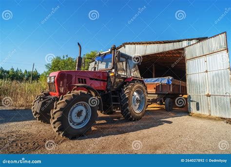 Tractor Unloading Grain Harvest To Granary Storage On Farm Stock Photo