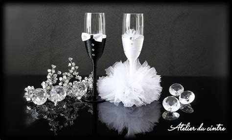 Two Champagne Flutes With White Tulle And Crystal Balls On The Table