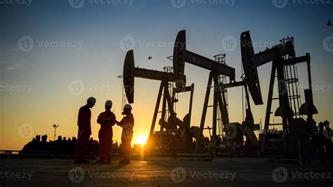 Silhouette Of Oil Workers Working In The Evening And Beautiful Sunset