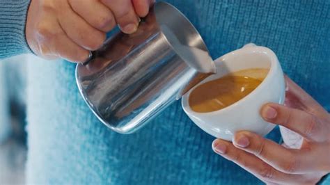 Barista Prepares Cappuccino And Pours Milk From Pitcher Into Espresso