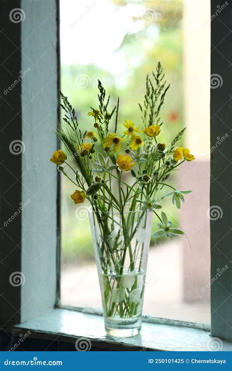 Bouquet Of Beautiful Wildflowers In Glass Vase On Window Sill Indoors