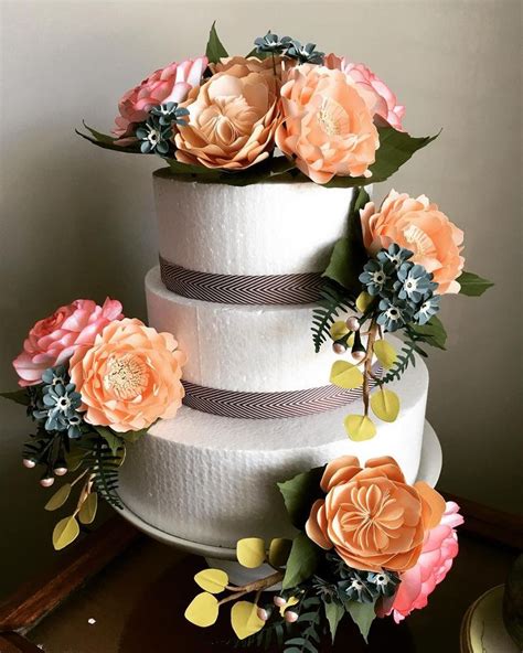 A Three Tiered Cake With Flowers On Top