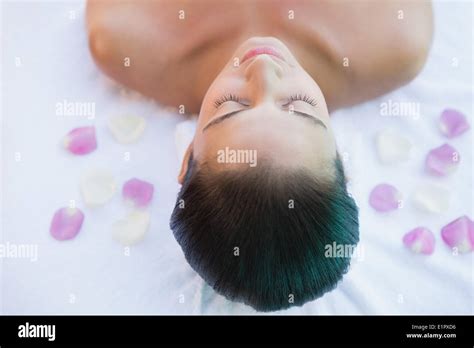 Calm Brunette Lying On Towel With Rose Petals Stock Photo Alamy