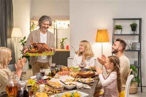 Familia Alegre Sentada Junto A Una Mesa Festiva Servida Con Comida