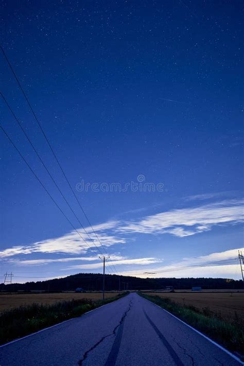 Long Desolate Stretch Of Highway With Tall Power Lines Running