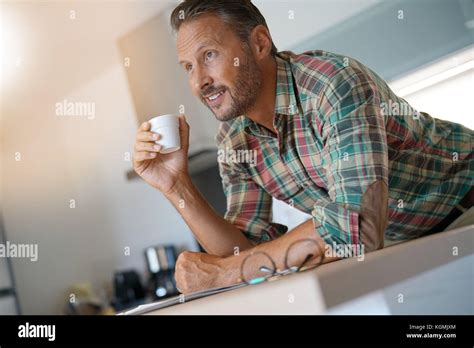 Smiling Mature Man Drinking Coffee In Home Kitchen Stock Photo Alamy