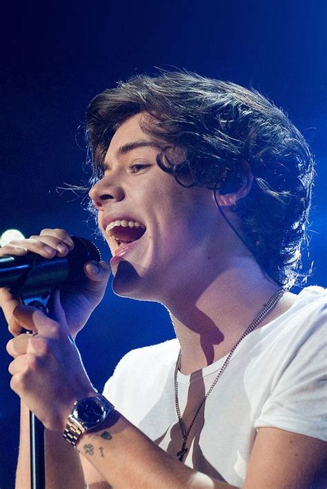 a young man singing into a microphone on stage