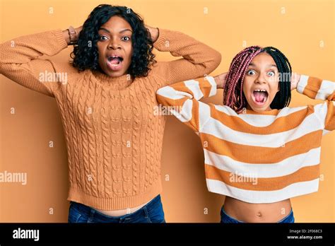 Beautiful African American Mother And Daughter Wearing Wool Winter Sweater Crazy And Scared With