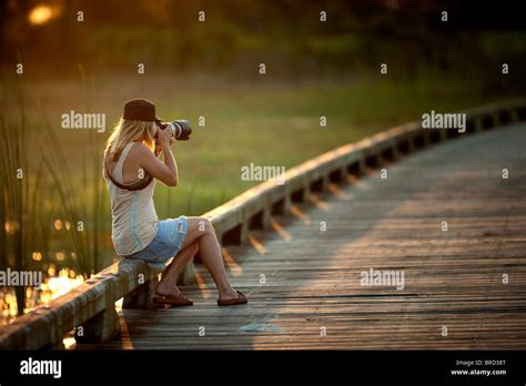 Girl photographing at sunset Stock Photo - Alamy