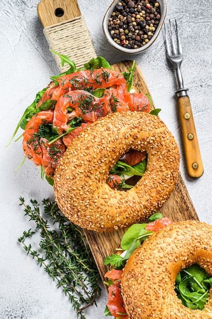 Sándwich de bagels de salmón ahumado con queso tierno y rúcula sobre