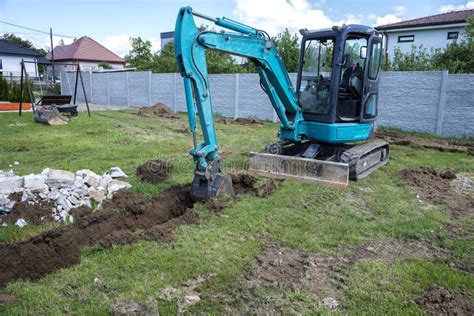 Small Excavator is Digging a Foundation for a House Stock Photo - Image ...