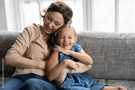Happy Mature Grandmother And Granddaughter Having Fun Tickling On