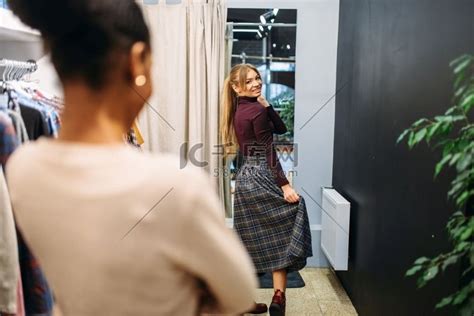 两位女顾客在更衣室里挑选衣服购物报纸杂志人物特写高清摄影大图 千库网