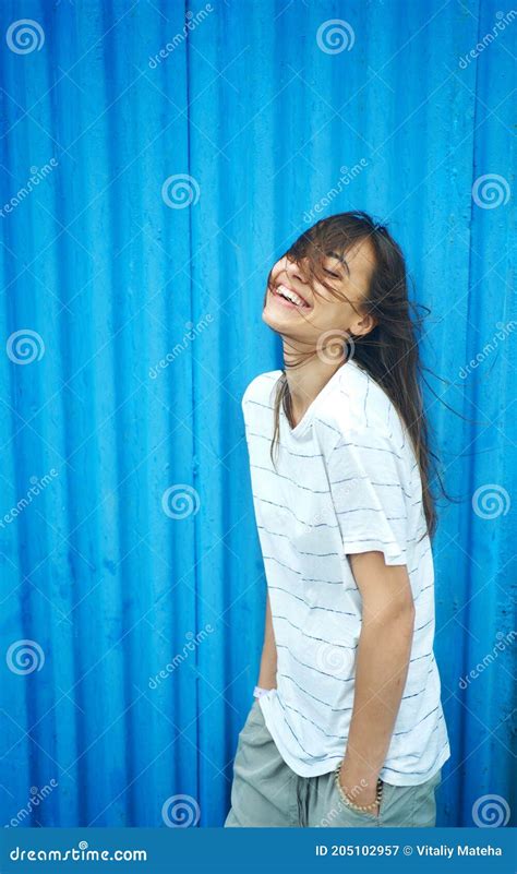 Fun Friendly Brunette Woman With Blowing Hair Giggling To Herself