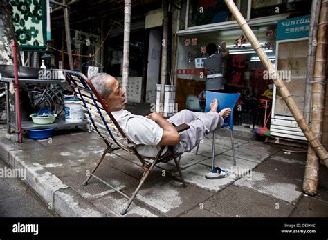 A Man Sleeping Outside The Door Of His Business Shanghai China Stock